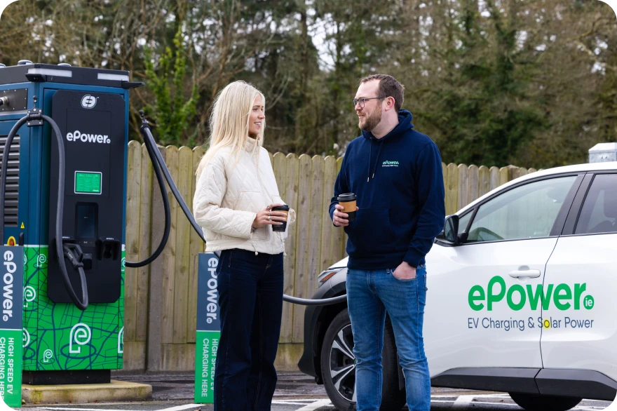 Two ePower employees standing on the parking lot next to ePower charger and car